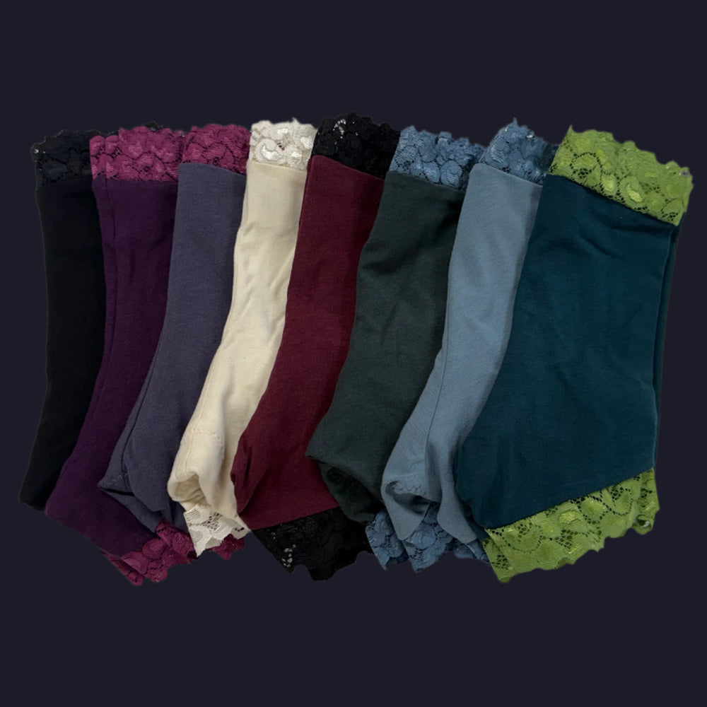Set of colorful lace-trimmed leggings arranged in a row on a light gray background.